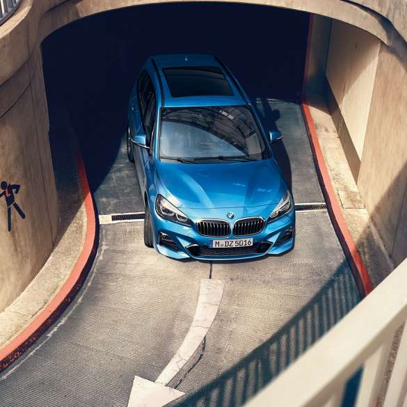 Egy többszintes parkolóházban mozgó BMW 2 Gran Tourer BMW 2 Gran Tourer, F46, 2018, Misano kék metál, egy többszintes parkolóházban mozgó autó felülnézetből