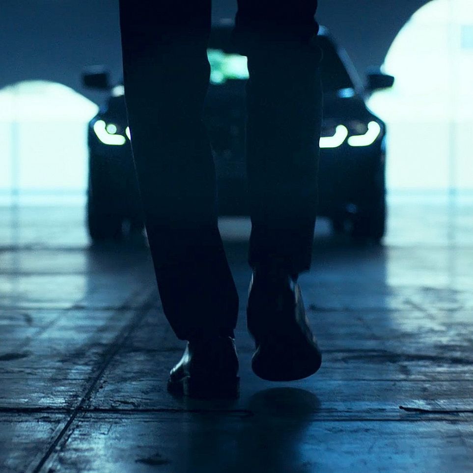BMW 3-as Limousine, orr-rész. Egy hátulról látható férfi egy aszfalton álló BMW 3-as Limousine előtt megy el.