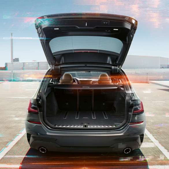 BMW 3-as Touring, hátulnézet nyitott csomagtérajtóval Egy nyitott csomagtérajtóval egy parkolóhelyen álló BMW 3-as Touring hátulnézetből, városi környezetben