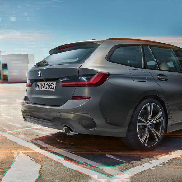 BMW 3-as Touring, háromnegyedes hátulnézetből egy parkolóhelyen Egy parkolóhelyen álló BMW 3-as Touring háromnegyedes hátulnézetből, városi környezetben.