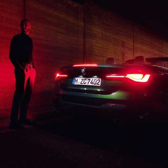 Rézsútos hátulnézet nyitott vászontetővel, BMW 4 Cabrio, G23, 2020 BMW 4 Cabrio, G23, 2020, Sanremo zöld metál, egy rézsútos hátulnézetből látható, nyitott vászontetős autó éjszaka