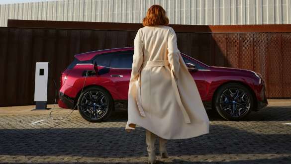 Connected Charging, BMW iX M60, i20, 2022, elektromos SUV, elektromos autó BMW iX M60, i20, 2022, elektromos SUV, elektromos autó, Connected Charging, egy nő áll egy BMW iX előtt