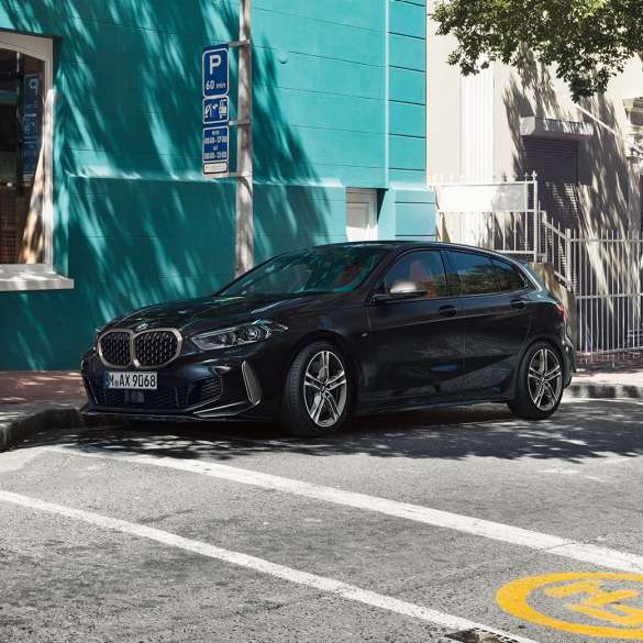 BMW M135i xDrive, háromnegyedes oldalnézet. Egy álló, Zafírfekete metálfényezésű új BMW M135i xDrive háromnegyedes oldalnézetből.