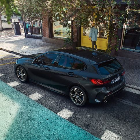 Egy álló BMW M135i xDrive. Egy álló, Zafírfekete metálfényezésű BMW M135i xDrive oldalról, felülnézetből.