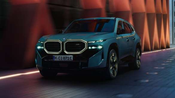 BMW XM, G09, V8-as plug-in hibrid, oldalnézet BMW XM, G09, V8-as plug-in hibrid, egy épület előtt álló autó oldalnézetből