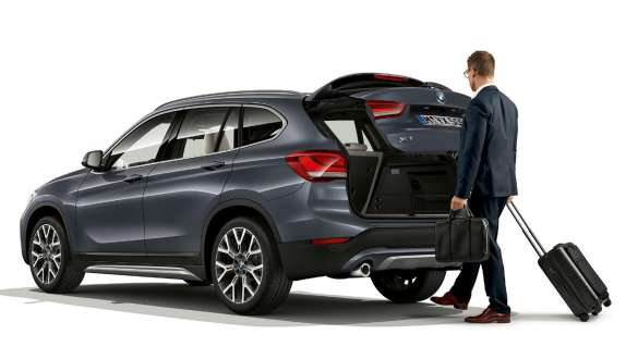 BMW X1, Automatikus csomagtértető-működtetés. BMW X1, álló autó nyitott csomagtértetővel.