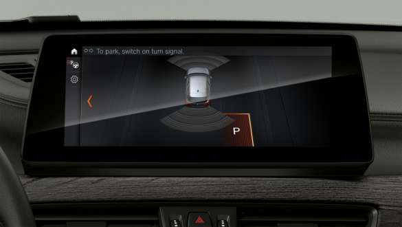 BMW X1, F48, a Parkolóasszisztens tartalmait mutató kijelző és a kezelőszervek BMW X1, F48 LCI, belső tér, középpontban a Driving Assistant Plus részét képező rendszerek tartalmait mutató kijelzőkkel és a kezelőszervekkel