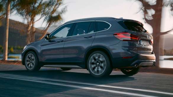 BMW X1, F48, rézsútos hátulnézet BMW X1, F48 LCI, egy hegyvidéki környezetben haladó autó rézsútos hátulnézetből