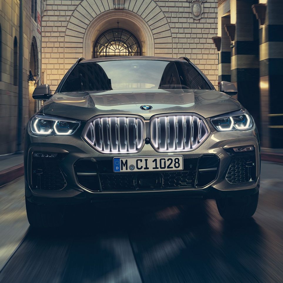 A BMW X6 az „Iconic Glow” BMW vesékkel. A BMW X5 elölnézetből, városi környezetben.