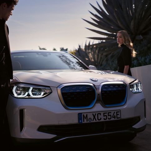 BMW iX3, G08, rézsútos elölnézet a BMW i vesékkel BMW iX3, G08, 2020, egy Kristály fehér metálfényezésű autó rézsútos elölnézetből a BMW i vesékkel