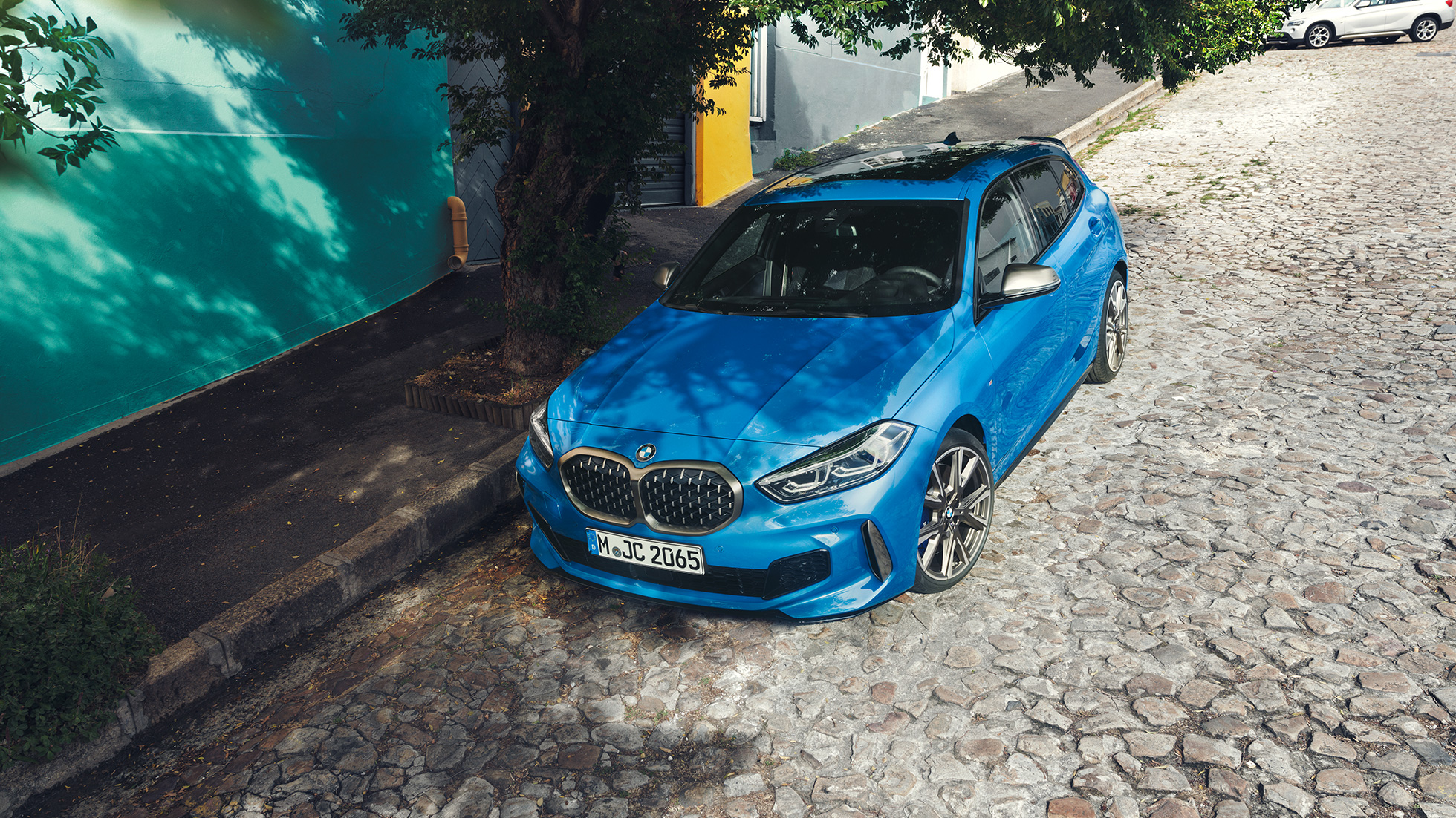 Egy BMW 1-es az út szélén. Egy Misano kék metál, az út szélén álló BMW 1-es felülnézetből.