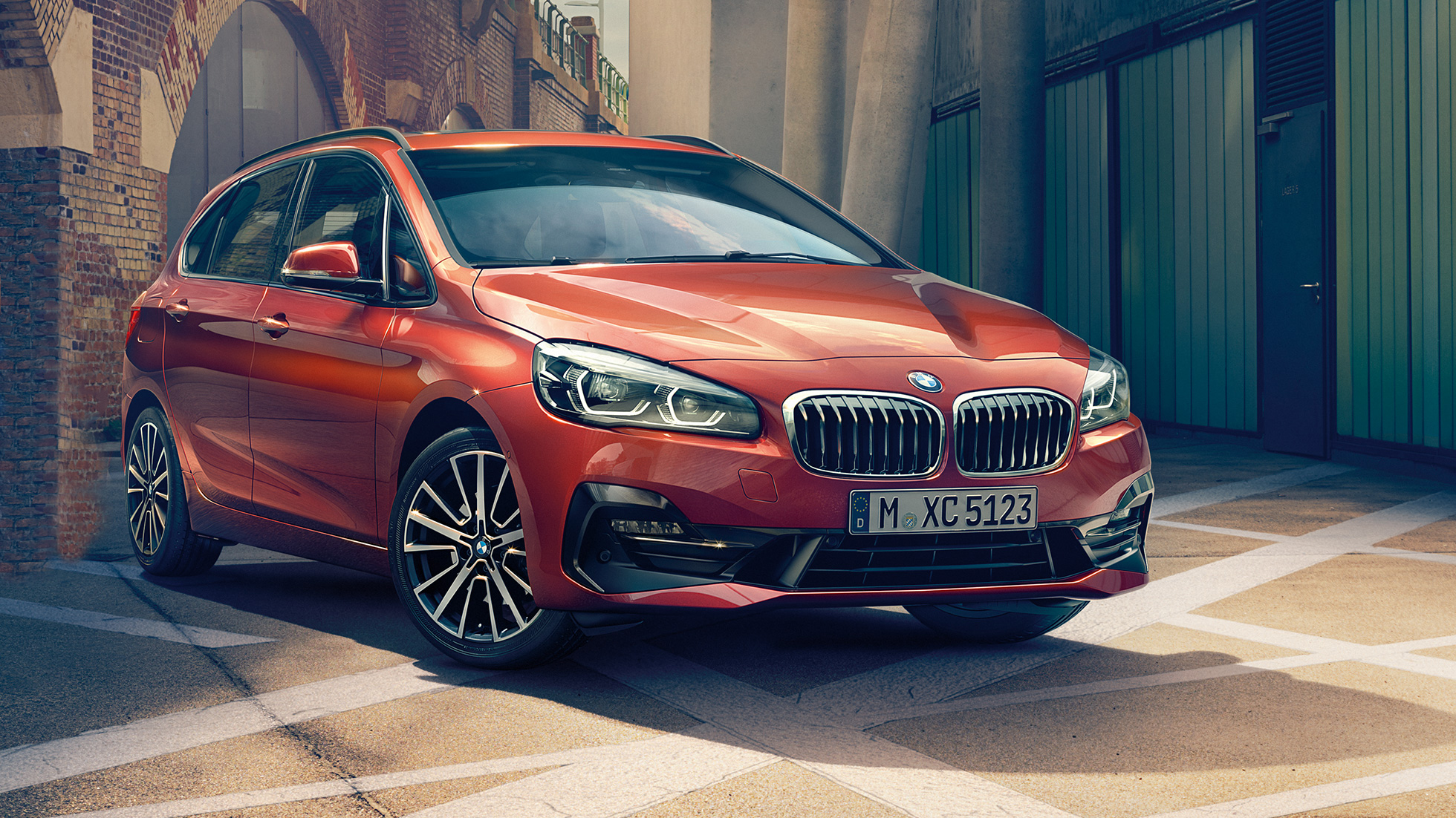 Külső megjelenés, BMW 2 Active Tourer BMW 2 Active Tourer, F45, Sunset narancs metál, egy szűk utcában álló autó rézsútos elölnézetből