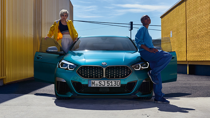 BMW 2 Gran Coupé, F44, elölnézet BMW 2 Gran Coupé, F44, egy Snapper Rock fényezésű, két személy társaságában lévő, elölnézetből látható autó nyitott első ajtókkal