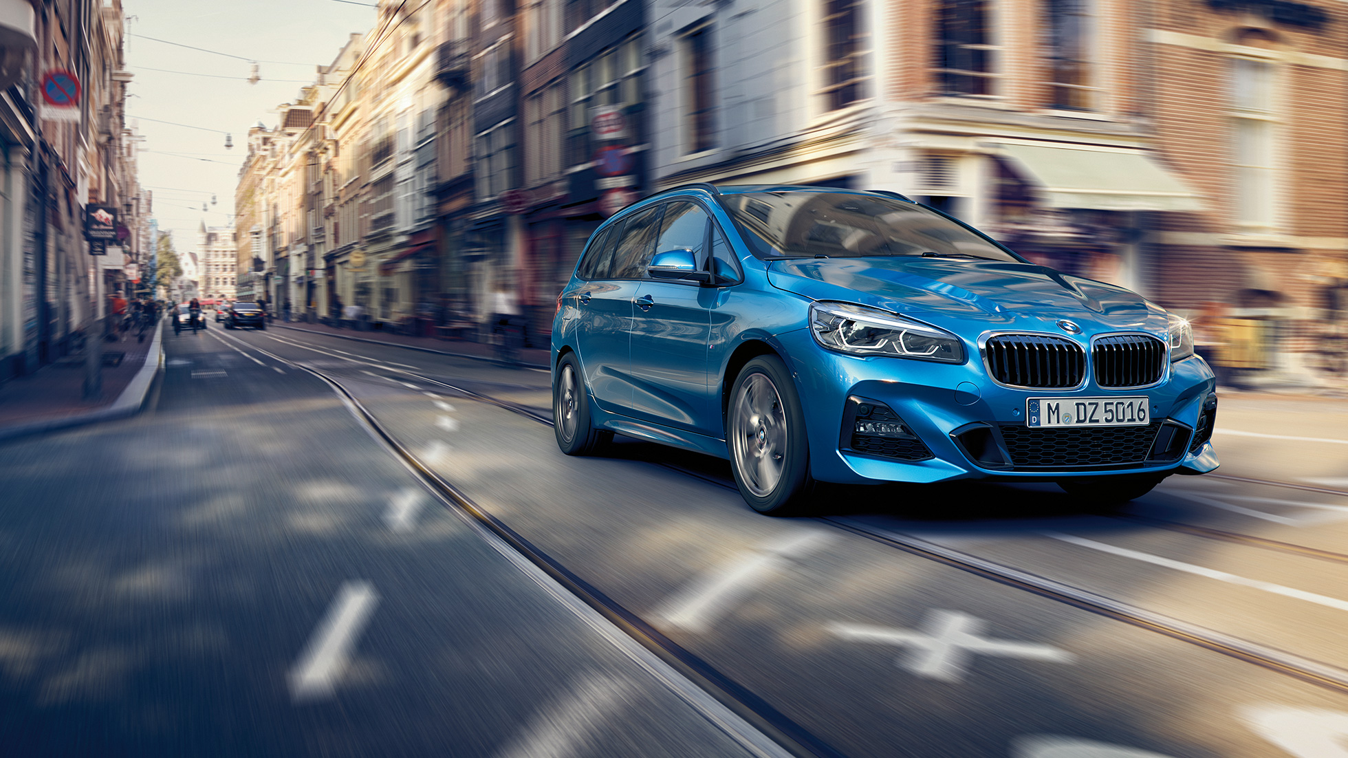 Dinamizmus, BMW 2 Gran Tourer Dinamizmus, BMW 2 Gran Tourer, F46, 2018, Misano kék metál, egy belvárosban haladó autó rézsútos elölnézetből