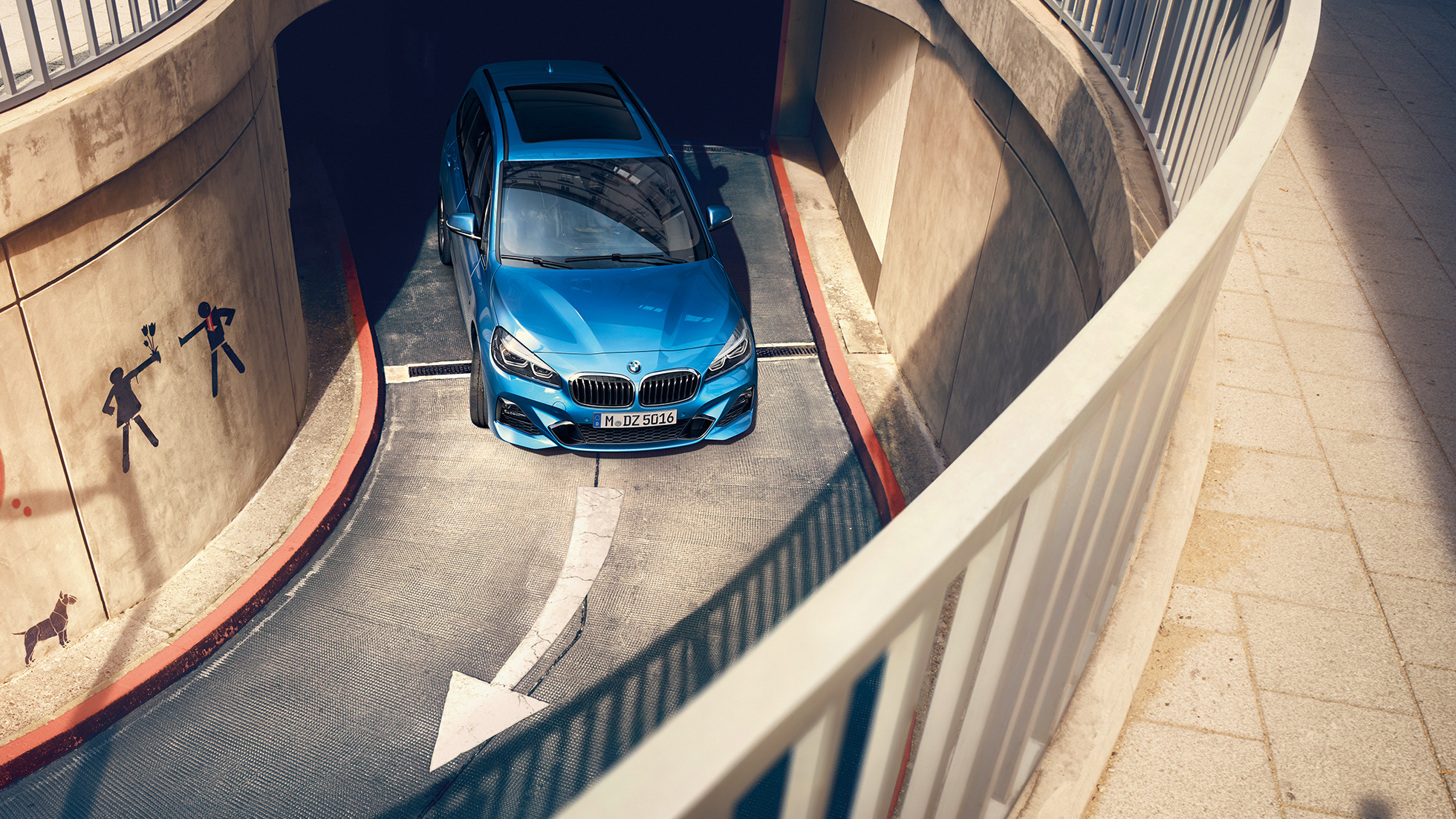 Egy többszintes parkolóházban mozgó BMW 2 Gran Tourer BMW 2 Gran Tourer, F46, 2018, Misano kék metál, egy többszintes parkolóházban mozgó autó felülnézetből