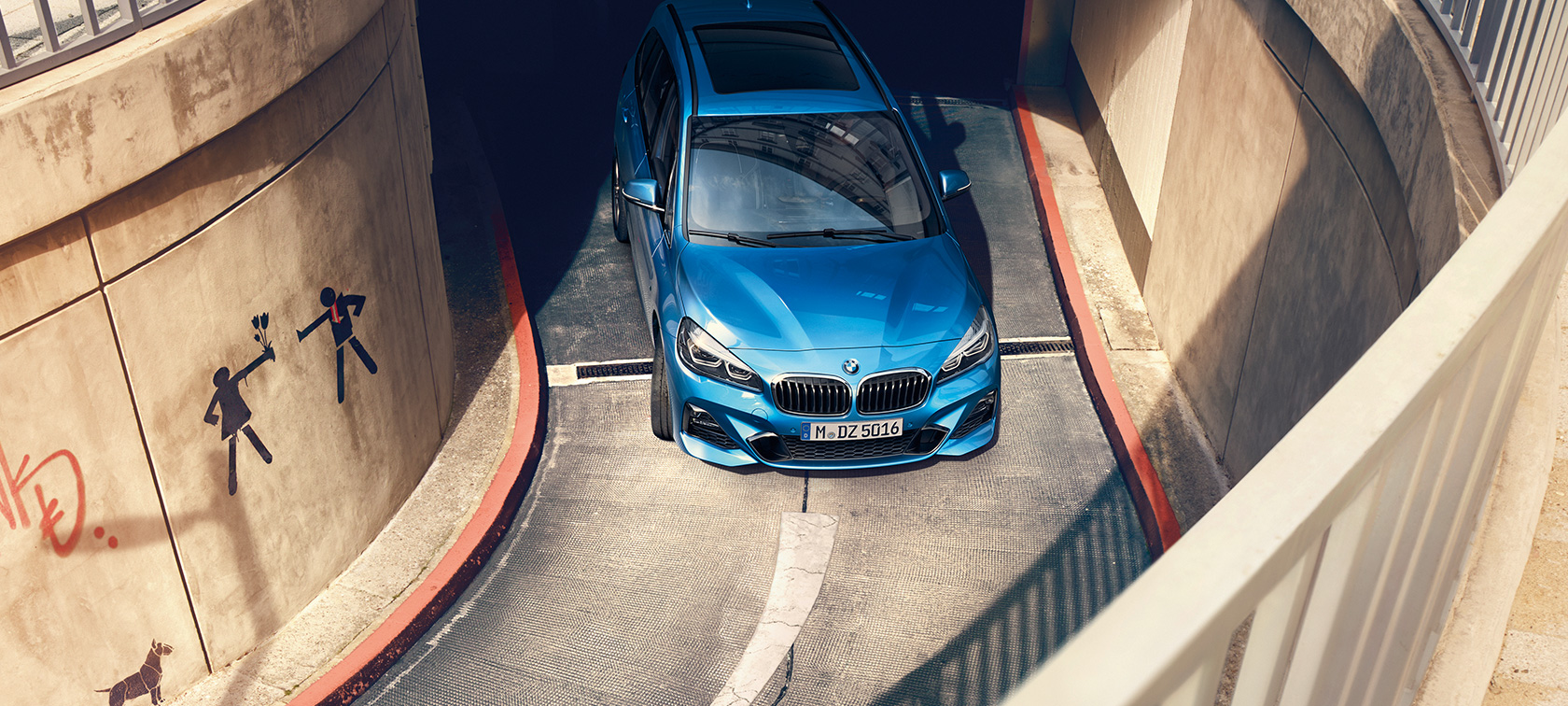 BMW 2 Gran Tourer, egy többszintes parkolóházban haladó autó felülnézetből BMW 2 Gran Tourer, F46, Misano kék metál, egy többszintes parkolóházban haladó autó felülnézetből