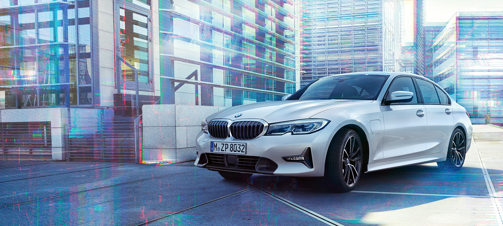 BMW 330e Limousine. A BMW 330e Limousine háromnegyedes elölnézetből, városi háttér előtt.