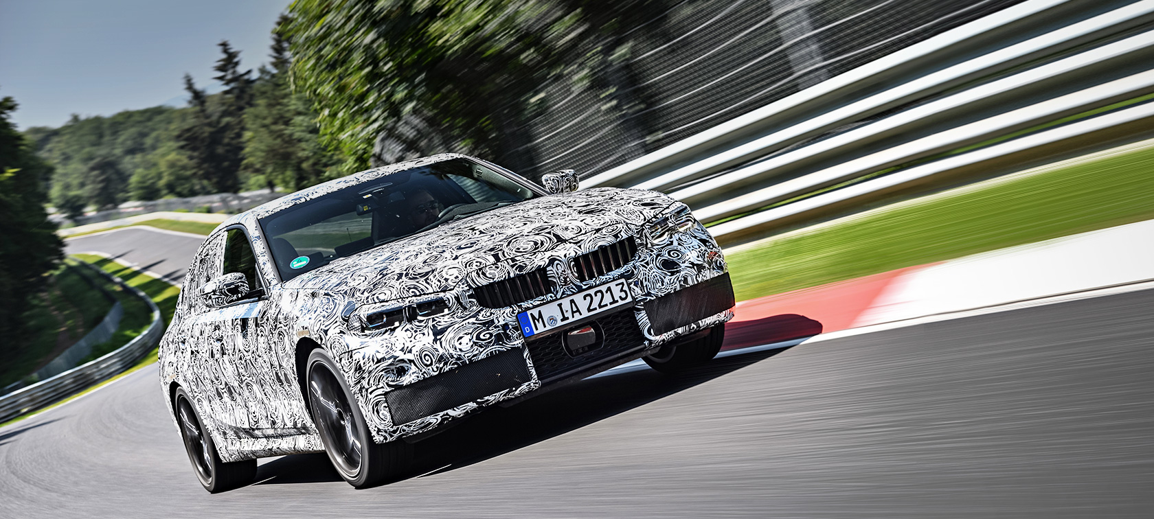 Akcióban a BMW 3-as. A BMW 3-as álcázott prototípusa a versenypálya kanyarjában.