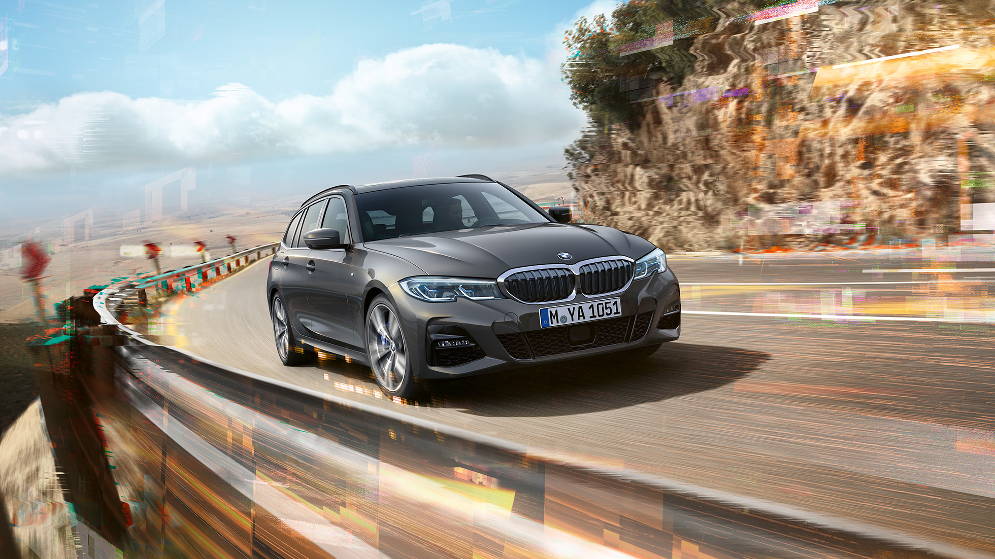 BMW 3-as Touring, háromnegyedes elölnézet, dizájn Egy hídon áthaladó BMW 3-as Touring háromnegyedes oldalnézetből, vidéki tájjal a háttérben.