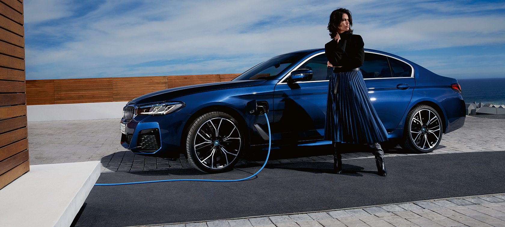 BMW 5 Limousine plug-in hibrid, 2021, G30, egy töltés alatt álló autó oldalnézetből BMW 5 Limousine plug-in hibrid, 2021, G30, egy töltés alatt álló autó egy modell társaságában