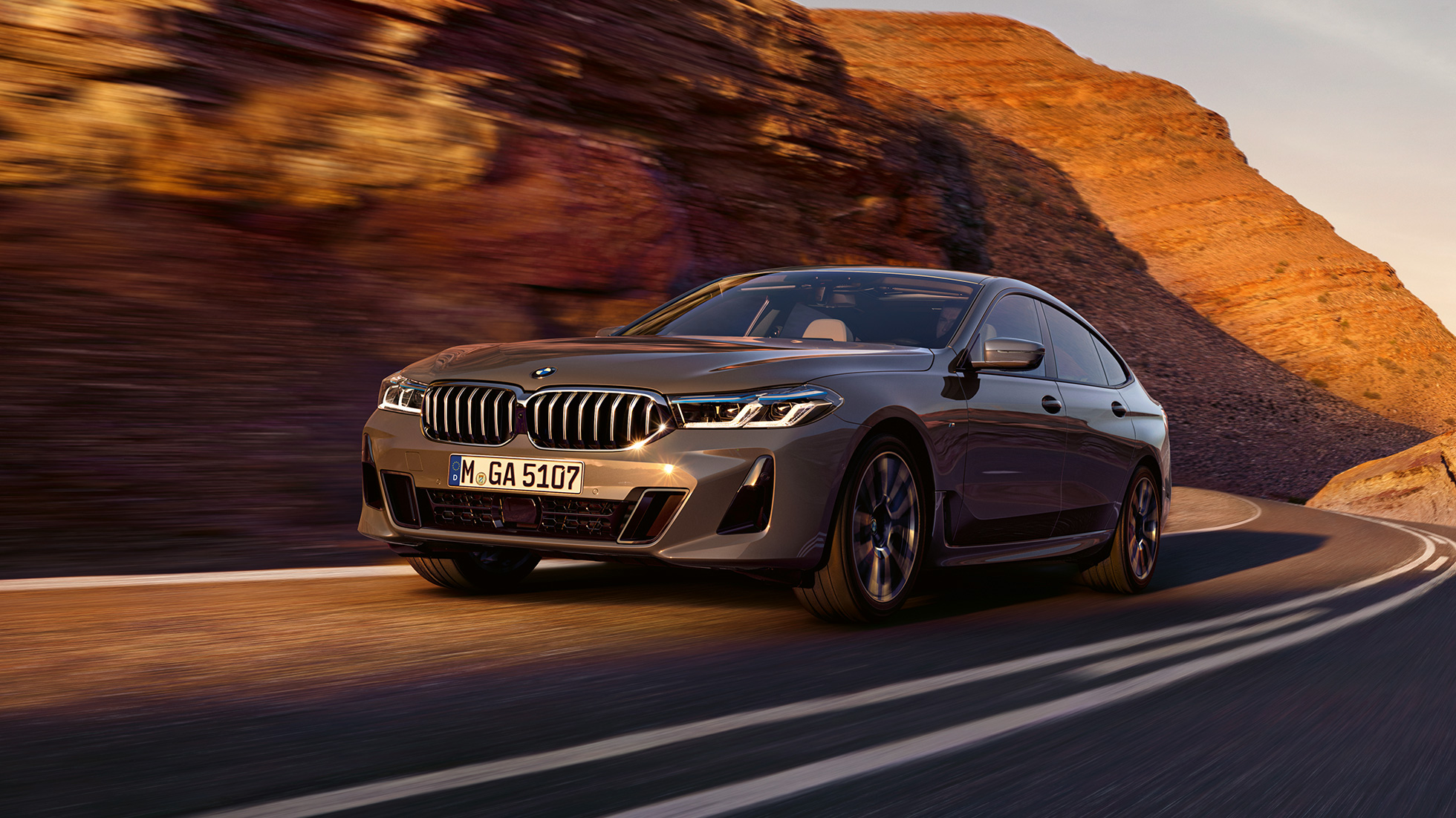 BMW 6 Gran Turismo, G32, 2020 BMW 6 Gran Turismo, 640i xDrive, G32, 2020, egy vidéki tájon haladó, Bernina szürke fényezésű autó rézsútos elölnézetből