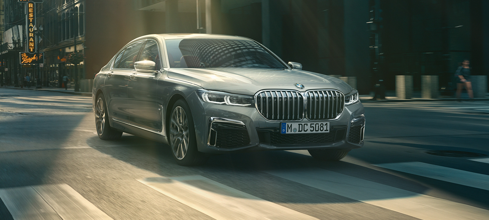 Egy mozgó BMW 7 Limousine rézsútos elölnézetből Egy rézsútos elölnézetből látható, szürke BMW 7 Limousine városi környezetben halad