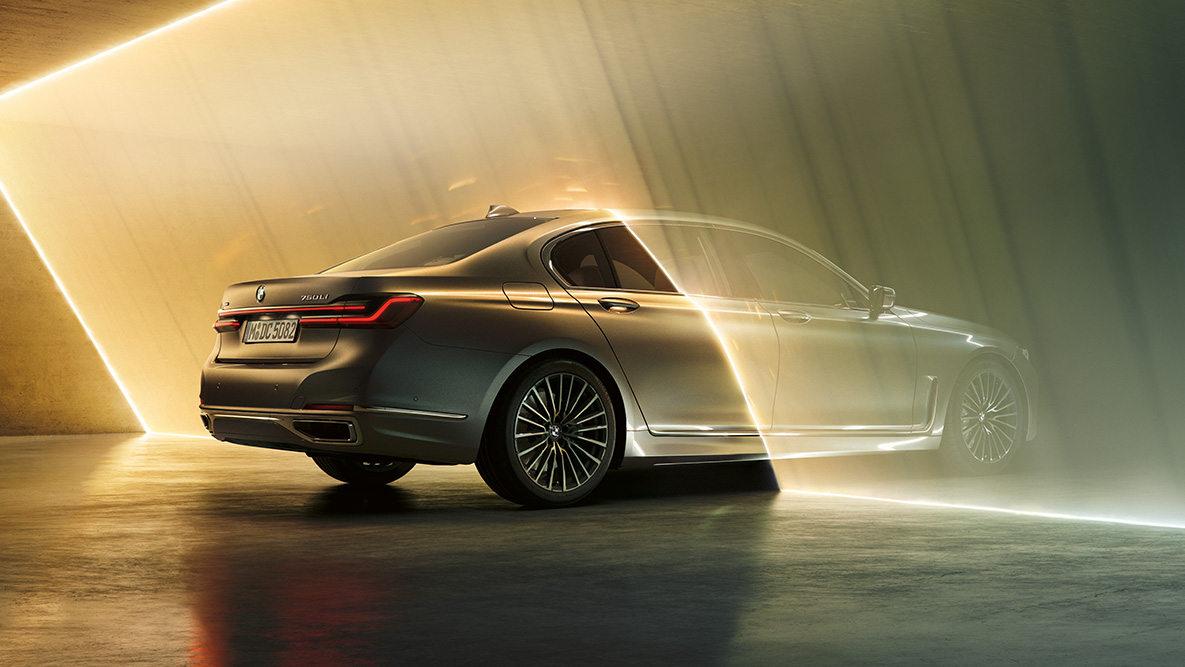 Egy Bernina szürke BMW 7 Limousine Egy Bernina szürke BMW 7 Limousine rézsútos hátulnézetből, fénysugarakkal körbevéve