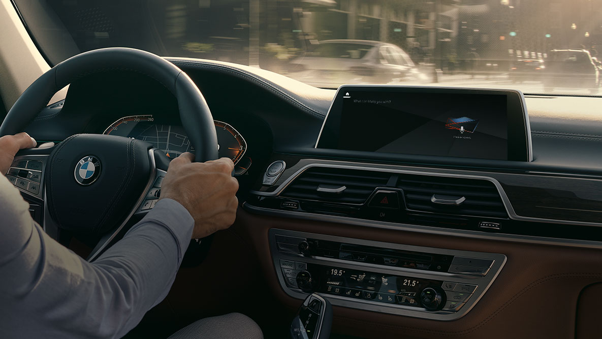 BMW Intelligent Personal Assistant BMW Intelligent Personal Assistant: egy férfi vezet egy BMW-t, amelyben közelről látható a Live Cockpit Professional felszereltség