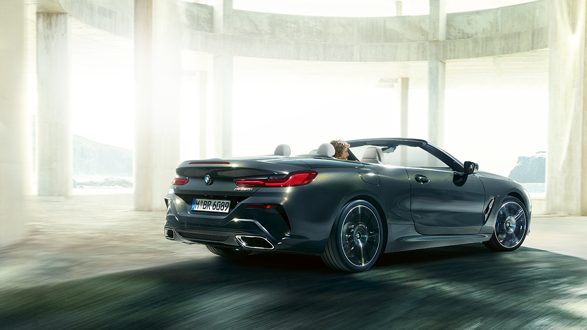 BMW M850i xDrive nyitott vászontetővel, menet közben, oldalnézetből. BMW M850i xDrive nyitott vászontetővel, menet közben, oldalnézetből.