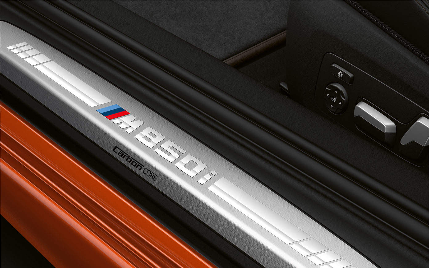 BMW 8 Coupé, M850i ajtóküszöb. Közeli felvétel egy BMW 8 Coupé „M850i” felirattal ellátott ajtóküszöbéről.