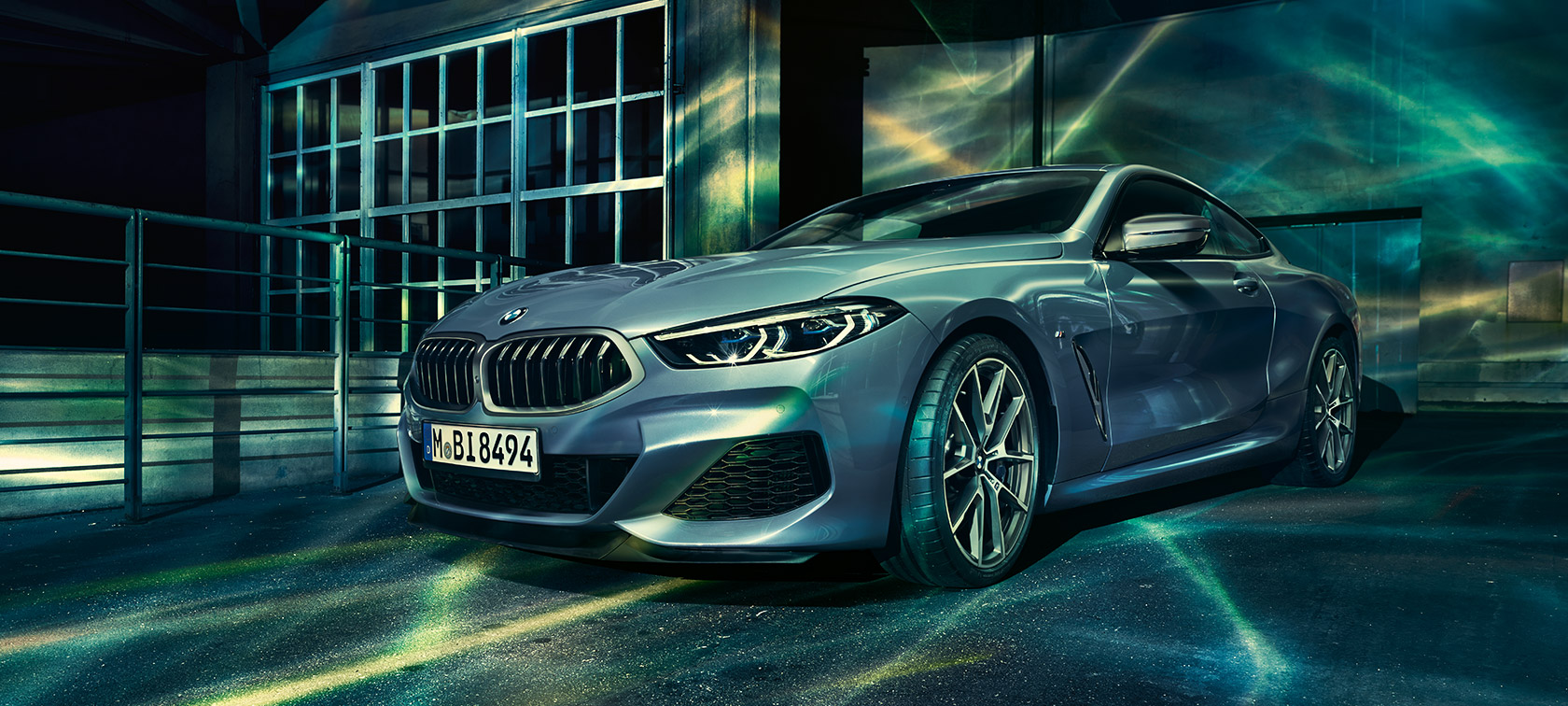 BMW 8 Coupé, háromnegyedes elölnézet. A BMW 8 Coupé háromnegyedes elölnézetből, egy gyárépület előtt.