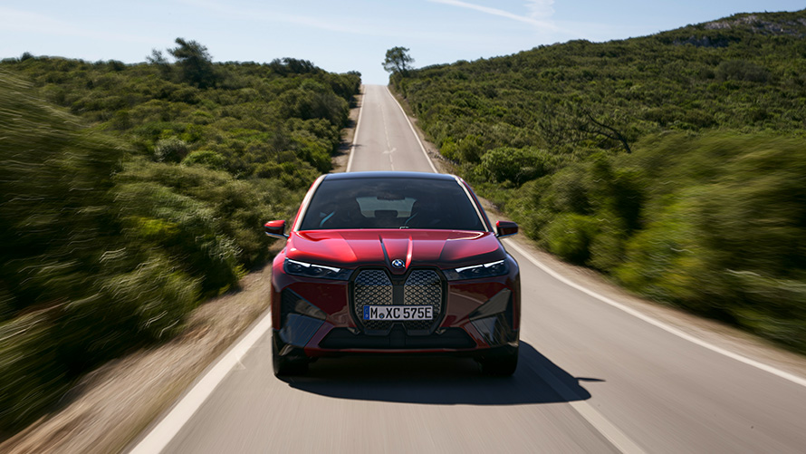 BMW iX, i20, elektromos SUV, BMW iX, xDrive50, hatótáv BMW iX, i20, 2021, elektromos SUV, BMW iX, xDrive50, Aventurin vörös, egy utcán haladó autó, hatótáv
