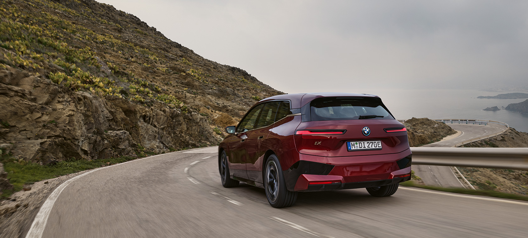 BMW iX, i20, 2021, elektromos SUV, BMW iX xDrive50, egy tengerparti úton haladó autó BMW iX, i20, 2021, elektromos SUV, BMW iX xDrive50, egy tengerparti úton haladó, Aventurin vörös fényezésű autó