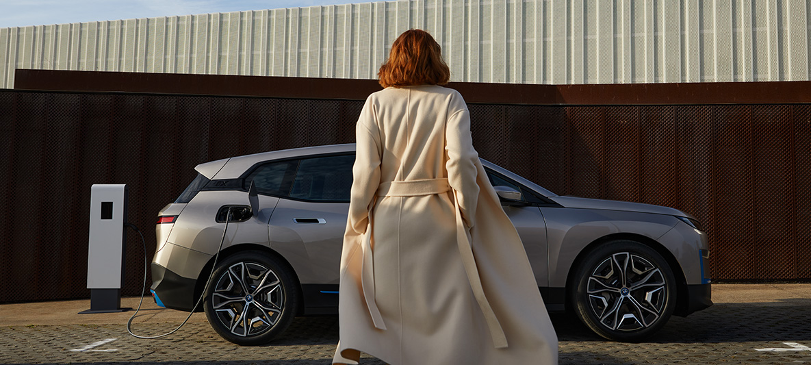 BMW iX, egy álló autó oldalnézetből BMW iX, Kashmir ezüst, i20, egy álló, modell társaságában látható autó oldalnézetből
