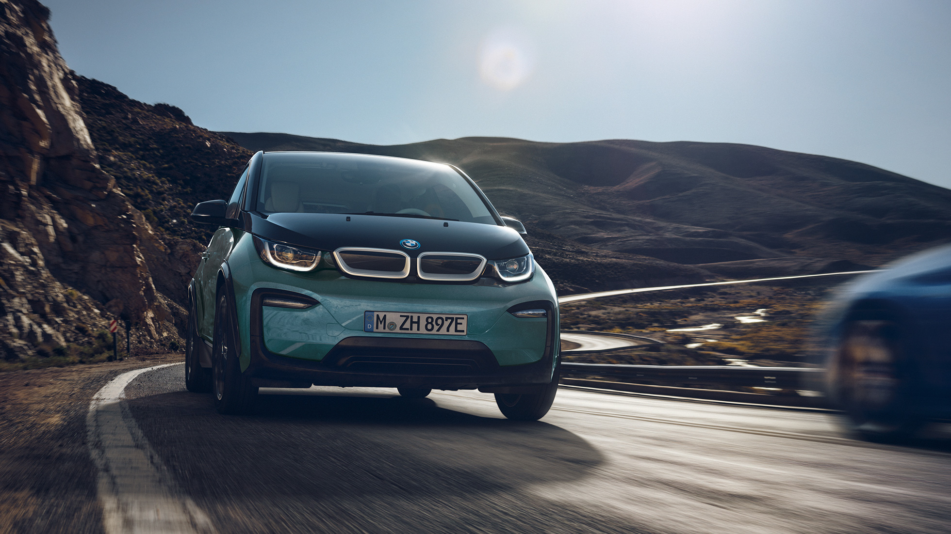 BMW i3, 2018, egy mozgó autó oldalnézetből BMW i3, i01, 2018, Jucaro bézs Frozen szürke metál kiemeléssel, egy városi környezetben haladó autó oldalnézetből
