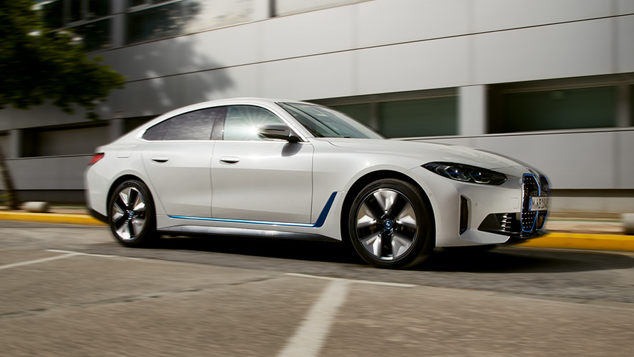 BMW i4, G26, 2021, egy épület előtt álló autó oldalnézetből BMW i4, G26, 2021, egy épület előtt álló autó oldalnézetből