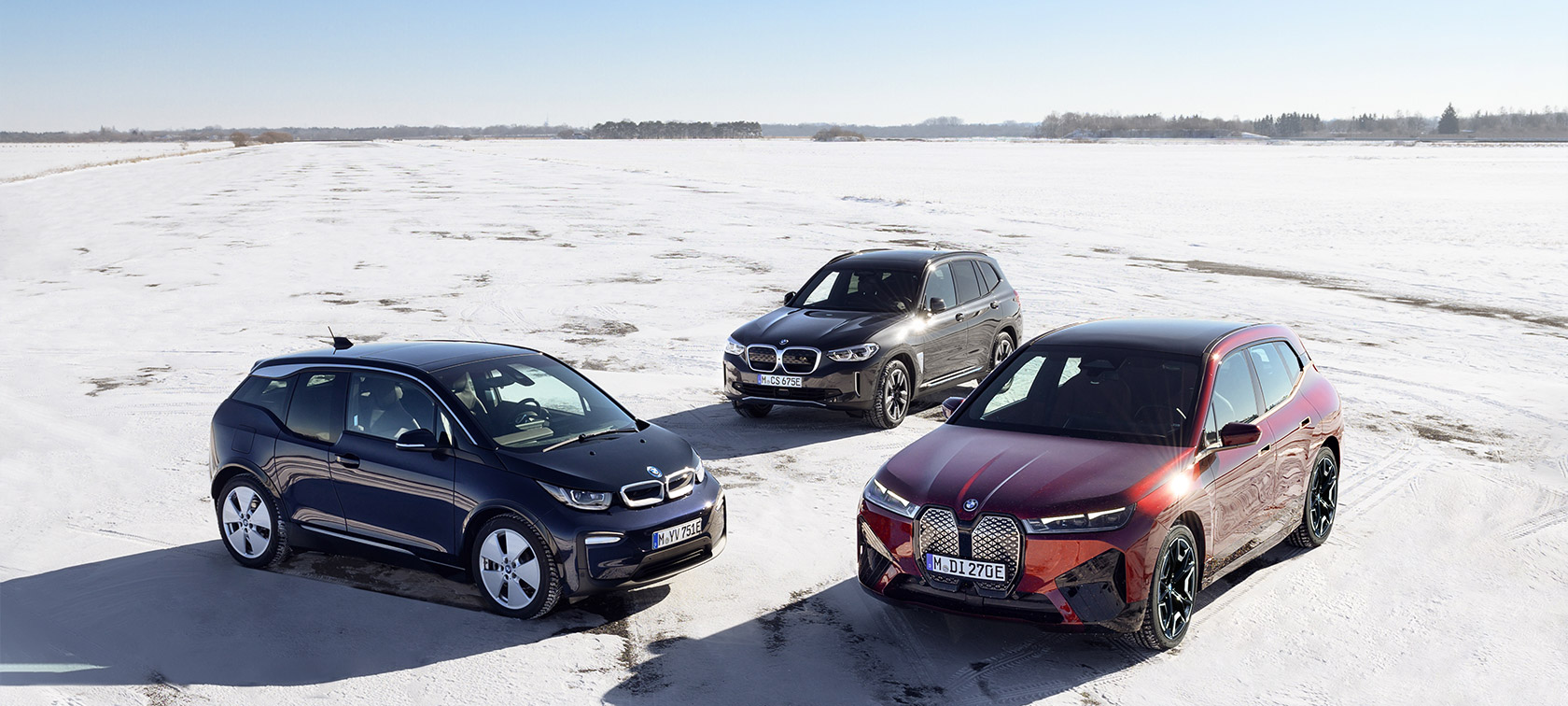 BMW elektromos autók felső rézsútos oldalnézetből BMW i modellek, homokon álló BMW elektromos autók felső rézsútos oldalnézetből