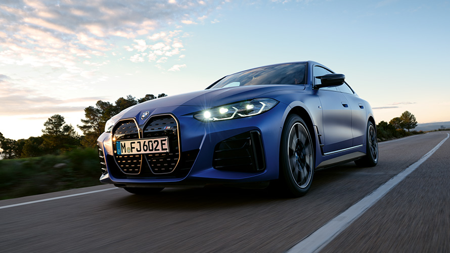 Rézsútos elölnézet, BMW i4 M50, G26, 2021, alsó elölnézet BMW i4 M50, G26, 2021, egy mozgó, BMW Individual Frozen Portimao kék metálfényezésű autó rézsútos alsó elölnézetből