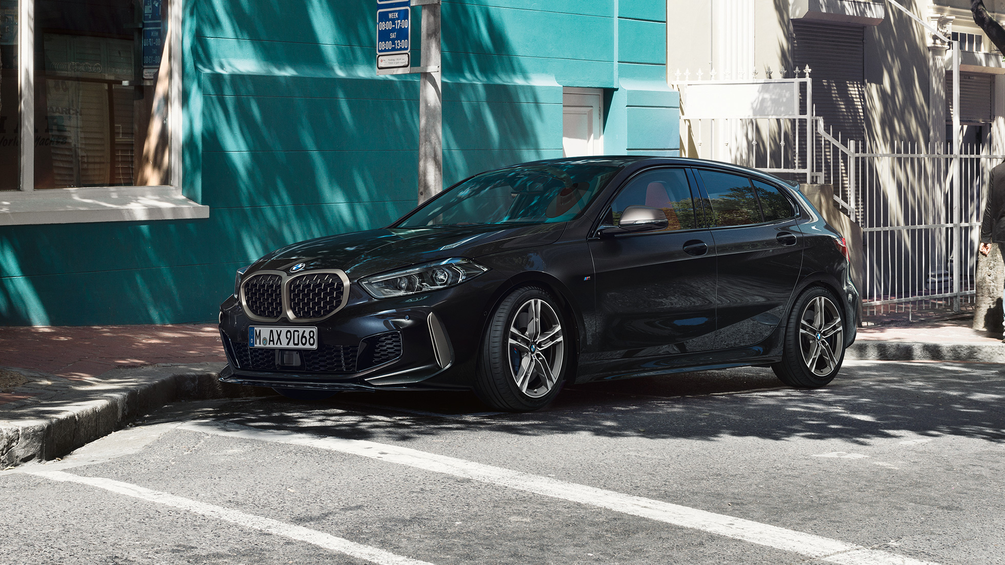 BMW M135i xDrive, háromnegyedes oldalnézet. Egy álló, Zafírfekete metálfényezésű új BMW M135i xDrive háromnegyedes oldalnézetből.