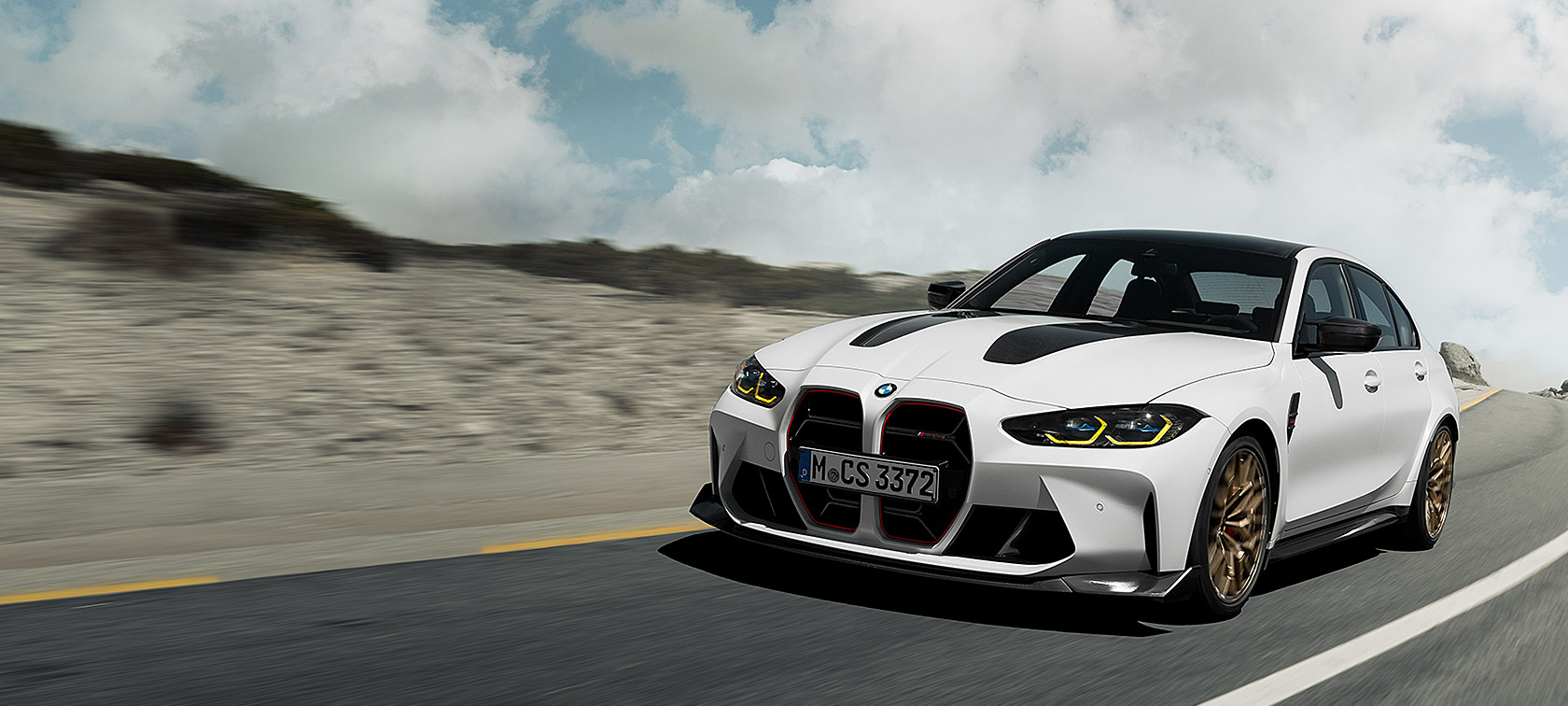 BMW M3 CS, G80, egy versenypályán haladó autó rézsútos elölnézetből