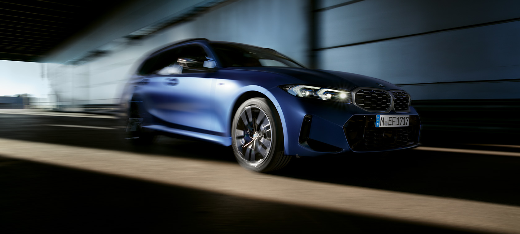 BMW M340i xDrive Touring, G21, egy mozgó autó rézsútos oldalnézetből BMW M340i xDrive Touring, G21, egy mozgó, Frozen Tanzanit kék fényezésű autó rézsútos oldalnézetből
