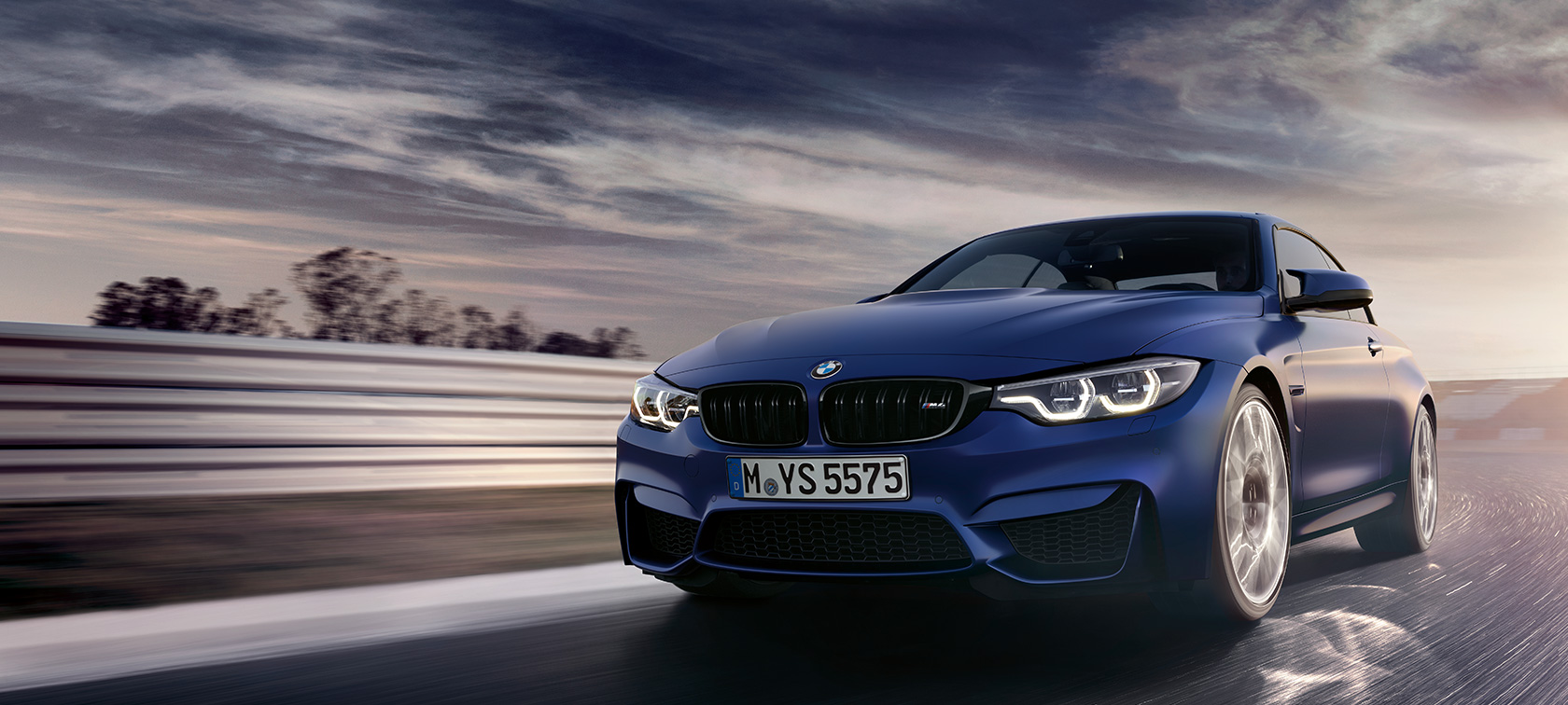 BMW M4 Cabrio BMW M4 Cabrio, egy versenypályán haladó autó rézsútos elölnézetből