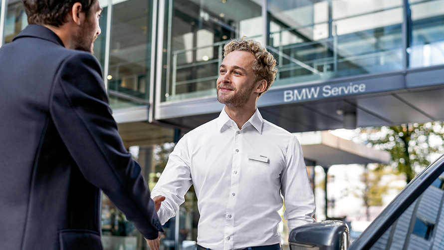 Egy BMW alkalmazott egy ügyfelet üdvözöl Egy BMW alkalmazott egy ügyfelet üdvözöl