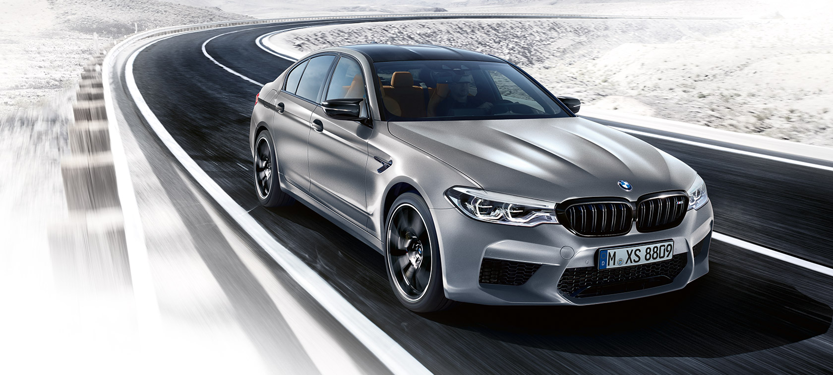 Dizájn. Egy BMW M5 Competition mozgás közben, háromnegyedes elölnézetből.