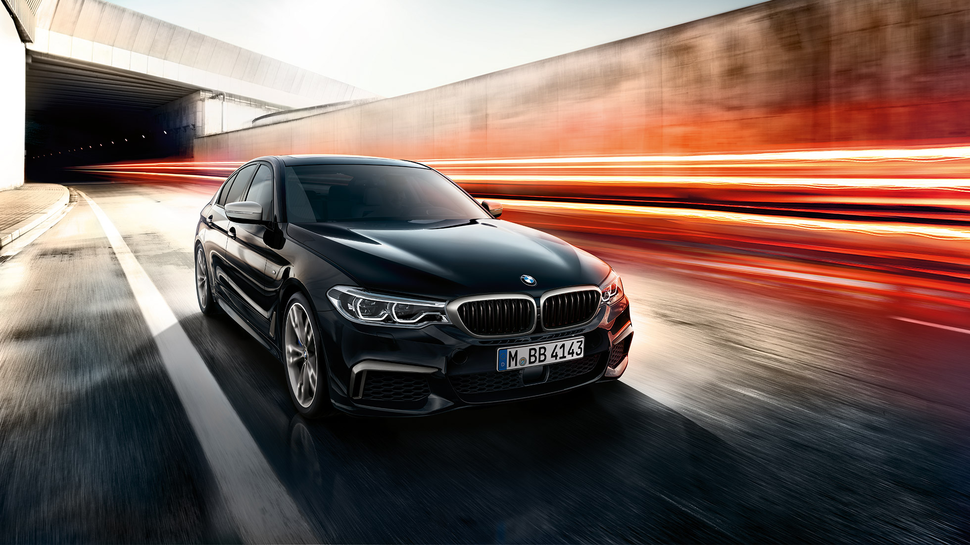 BMW M550i és BMW M550d. Egy BMW M550i és egy BMW M550d háromnegyedes elölnézetből, mozgás közben.