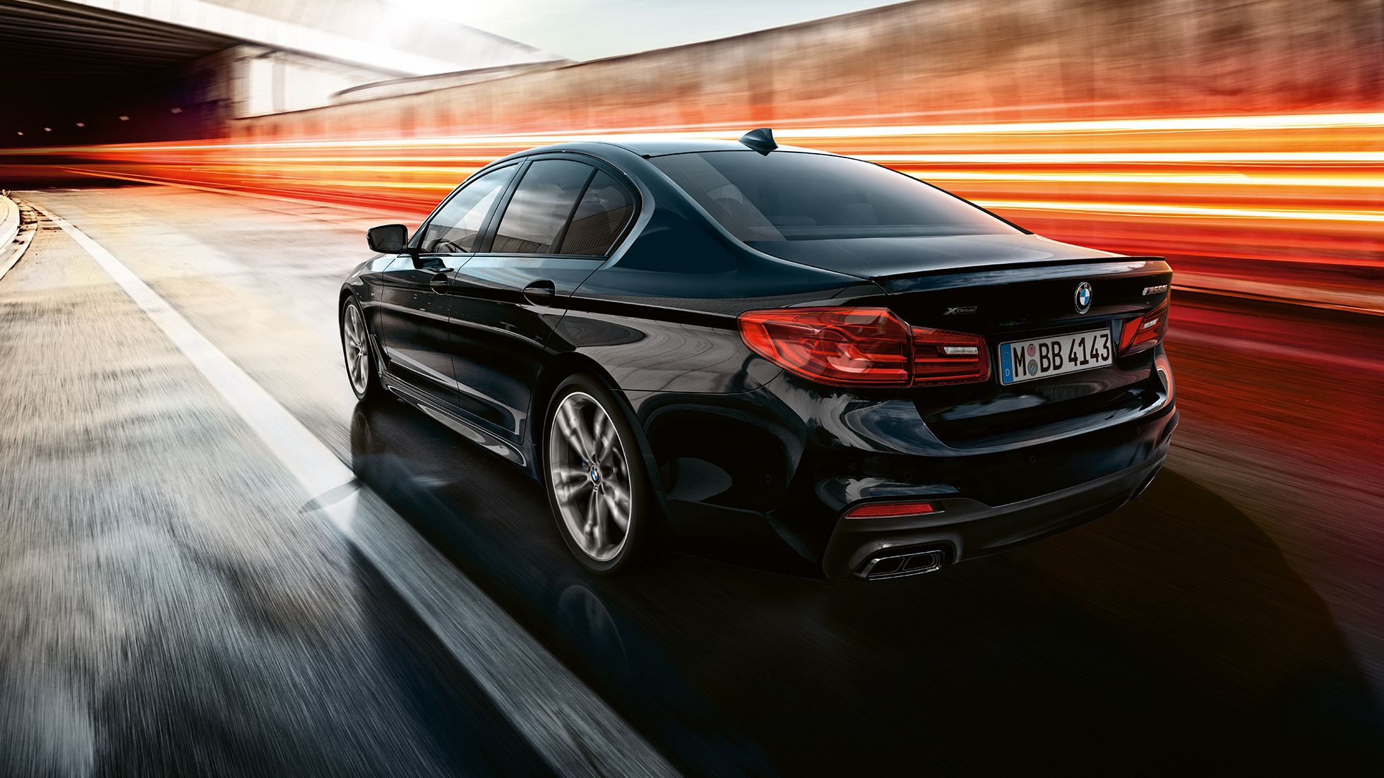 Dinamizmus. Egy BMW M550i és egy BMW M550d háromnegyedes hátulnézetből, mozgás közben.