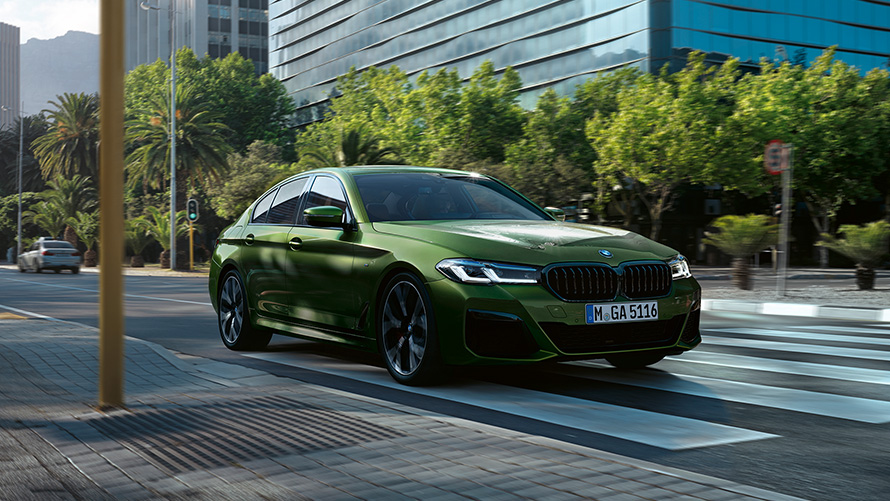 BMW M550i xDrive Limousine, G30 LCI, Facelift 2020, egy mozgó, BMW Individual Verde Ermes metálfényezésű autó rézsútos elölnézetből
