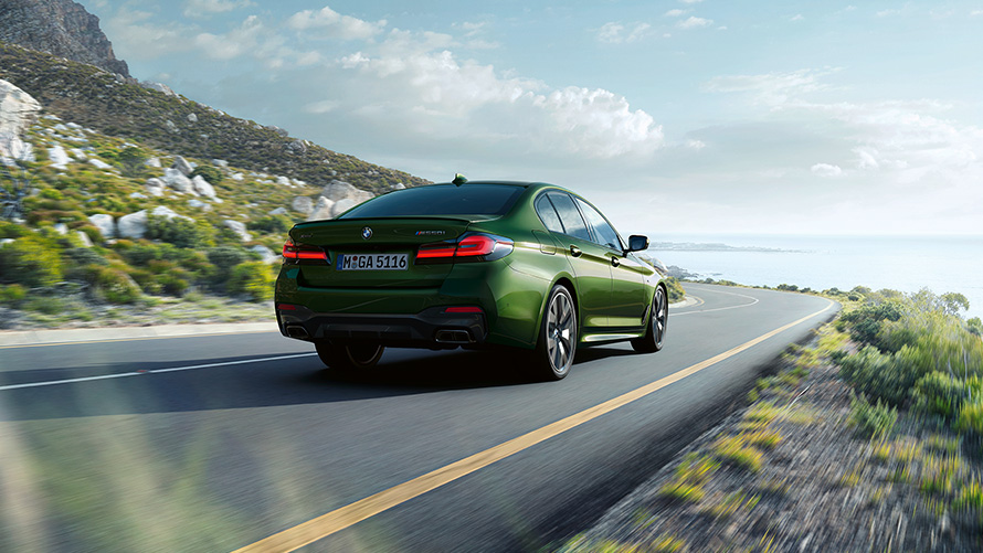 BMW M550i xDrive Limousine, G30 LCI, Facelift 2020, egy mozgó, BMW Individual Verde Ermes metálfényezésű autó hátulnézetből