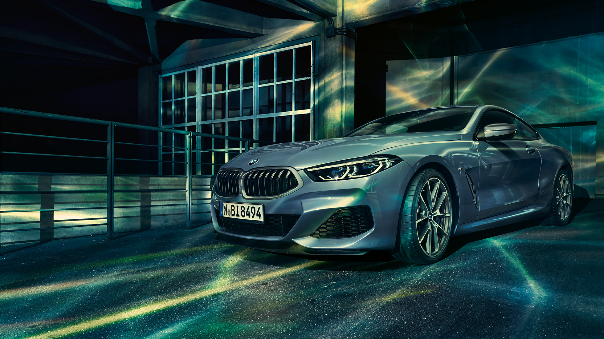 BMW M850i xDrive Coupé, háromnegyedes elölnézet. Egy épület előtt álló, Barcelona kék metálfényezésű BMW M850i xDrive Coupé háromnegyedes elölnézetből.