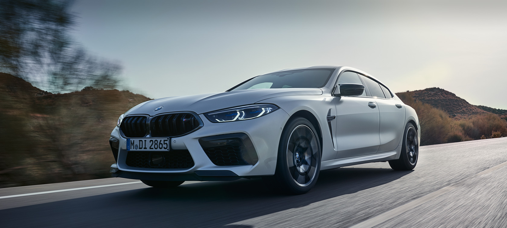 BMW M8 Competition Gran Coupé, F93 LCI, Facelift 2022, egy mozgó, BMW Individual Frozen briliáns fehér autó rézsútos elölnézetből